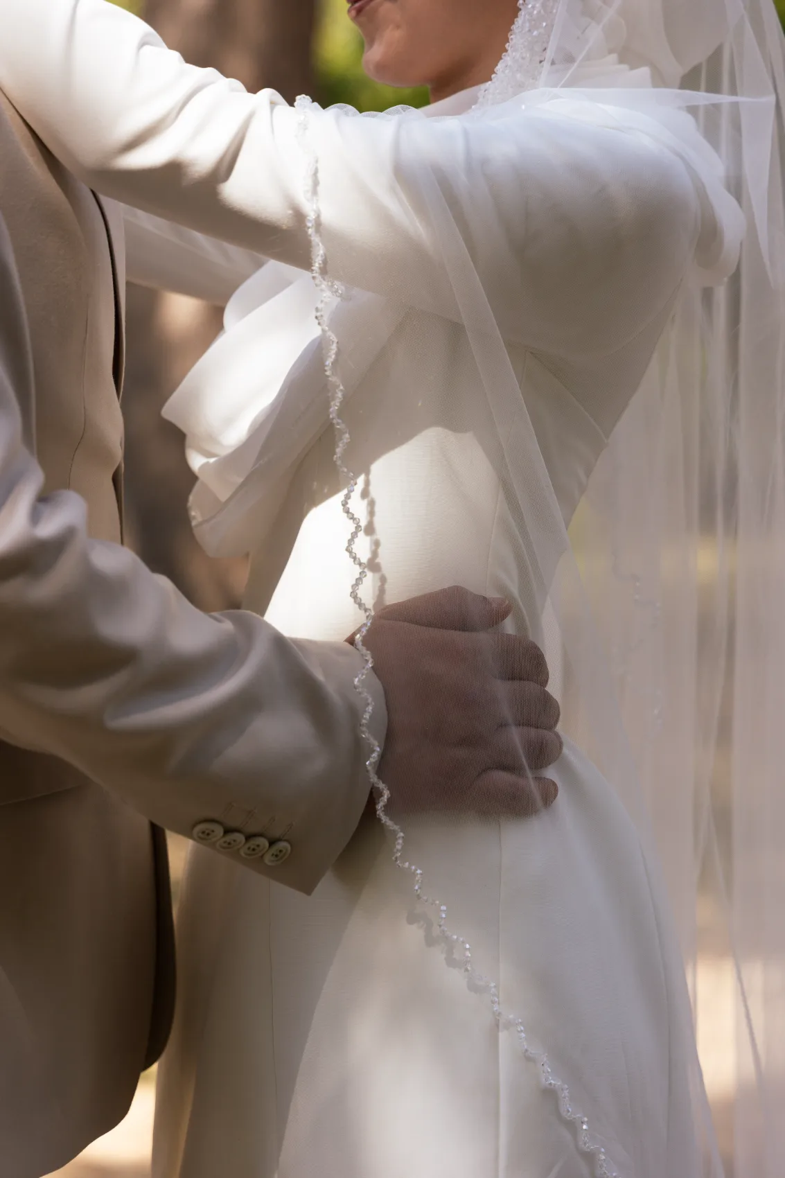 La mariée sous son voile pendant la cérémonie en extérieur
